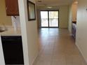 Open floorplan from kitchen to living room with tiled floor and sliding glass doors to the balcony at 4412 Spicewood Dr # D, Bradenton, FL 34208