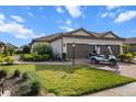 Charming home with a paver driveway, two-car garage, manicured lawn, and tropical landscaping at 4721 Tortona Ct, Bradenton, FL 34211