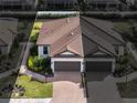 Stunning Mediterranean-style home with a tile roof, lush landscaping, and a brick paved driveway at 4721 Tortona Ct, Bradenton, FL 34211