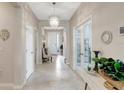 Bright hallway with a chandelier and glass-paneled doors at 5313 Halewood Ct, Bradenton, FL 34211