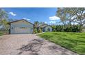 Beautiful light blue home with well-maintained lawn and brick paver driveway at 6079 Ravenwood Dr, Sarasota, FL 34243