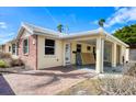Tan home with red brick accent wall and covered parking area on a sunny day at 6140 Midnight Pass Rd # A10, Sarasota, FL 34242