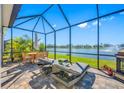 Relaxing screened-in patio with lake views, comfortable lounge furniture, and outdoor dining area, perfect for outdoor living at 6573 Devesta Loop, Palmetto, FL 34221