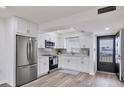 Modern white kitchen featuring stainless steel appliances and wood look floors at 102 46Th Avenue W Ter # 402, Bradenton, FL 34207