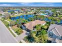 Stunning aerial view of a lakeside home with lush landscaping and a resort-style community pool at 12026 Perennial Pl, Bradenton, FL 34211
