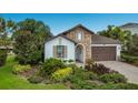 Charming single-story home with stone facade, arched entryway, and lush, well-maintained landscaping at 12026 Perennial Pl, Bradenton, FL 34211
