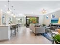 Bright and airy open-concept living room with modern decor, tile floors, and view to the outside at 12404 Golden Sage Dr, Sarasota, FL 34238