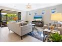 A cozy living room featuring neutral decor, tile floors, and natural light coming from a sliding glass door at 12404 Golden Sage Dr, Sarasota, FL 34238