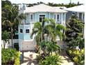 Beautiful two-story coastal home with lush landscaping, dual garages and a private balcony, perfect for beachside living at 130 50Th St, Holmes Beach, FL 34217