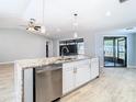 Modern kitchen island with stainless steel dishwasher and sink, plus white cabinetry at 13365 Drayton Dr, Spring Hill, FL 34609
