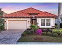 Inviting home showcasing a brick driveway, neutral paint, and lush landscaping at 15606 Leven Links Pl, Lakewood Ranch, FL 34202