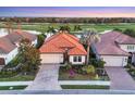 Charming single-story home featuring a well-manicured lawn and a vibrant red tile roof at 15606 Leven Links Pl, Lakewood Ranch, FL 34202