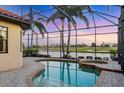 Sparkling pool and spa surrounded by a screened enclosure and mature landscaping at 15606 Leven Links Pl, Lakewood Ranch, FL 34202