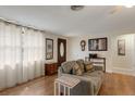 Cozy living room with wood floors, comfortable seating, and natural light from sheer curtains at 3053 Concord St, Sarasota, FL 34231