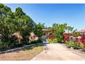 Home exterior with lush, mature landscaping and a concrete driveway at 3208 Vivienda Blvd, Bradenton, FL 34207