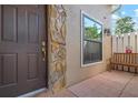 Close-up of the front door with stone accents, window, bench and walkway to add a touch of charm at 3296 Tallywood Ct # 7097, Sarasota, FL 34237