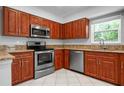This is a kitchen with wood cabinets, granite countertops, and stainless steel appliances at 3296 Tallywood Ct # 7097, Sarasota, FL 34237