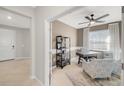 Bright home office featuring a ceiling fan, large window, a neutral color palette, and comfortable armchairs at 3603 Night Star Terrace, Parrish, FL 34219