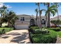 Charming home featuring tropical landscaping, a tile roof, and an attached two-car garage at 3617 Fair Oaks Pl, Longboat Key, FL 34228
