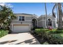 Charming home featuring tropical landscaping, a tile roof, and an attached two-car garage at 3617 Fair Oaks Pl, Longboat Key, FL 34228