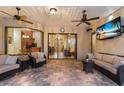 Inviting covered patio featuring comfortable seating, a ceiling fan, and TV perfect for outdoor entertainment at 3902 162Nd E Ave, Parrish, FL 34219
