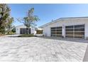 Two pristine white garages with glass doors stand on a beautiful driveway at 45 Cape Haze Dr, Placida, FL 33946