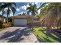 Beautiful single-story home featuring a tile roof, two-car garage and lush landscaping including palm trees at 5007 Palermo Dr, Punta Gorda, FL 33950