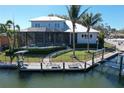 Aerial view of a waterfront home with a private dock, lift, and screen-enclosed pool at 5169 Sandy Shore Ave, Sarasota, FL 34242