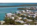 Stunning aerial view of a waterfront home with lush landscaping and access to the bay at 569 Juan Anasco Dr, Longboat Key, FL 34228