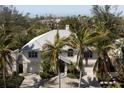 Beautiful two-story home featuring a brick driveway, mature landscaping, and a two-car garage at 569 Juan Anasco Dr, Longboat Key, FL 34228