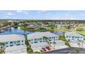 Stunning aerial view of condo community nestled by a serene lake with a fountain at 5743 Sabal Trace Dr # 101B57, North Port, FL 34287