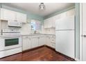 Charming kitchen with white cabinets, appliances, and hardwood floors offering a cozy and functional space at 5922 Garden Ln # A31, Bradenton, FL 34207