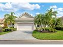 Charming home with a well-manicured lawn, mature palm trees, and a spacious driveway at 6547 Oakland Hills Dr, Lakewood Ranch, FL 34202