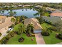 Expansive home with manicured lawn, lush landscaping, and serene lake views at 7017 Lennox Pl, University Park, FL 34201
