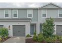 Charming two-story townhome with blue accents, gray garage door, and well-maintained landscaping at 8569 Canyon Creek Trl, Parrish, FL 34219