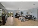 Spacious living room with tile floors, stylish decor, and sliding door leading to a patio at 9032 Excelsior Loop, Venice, FL 34293