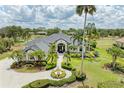 Aerial view of a luxury home, showcasing its mature landscaping, circular driveway, and extensive property at 10002 Cherry Hills Avenue Cir, Bradenton, FL 34202