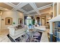 Grand living room with detailed ceiling, marble floors, elegant furnishings, and decorative columns at 10002 Cherry Hills Avenue Cir, Bradenton, FL 34202