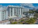 View of a modern white high-rise condo with a pool deck, palm trees, and elegant urban living at 101 S Gulfstream Ave # 4J, Sarasota, FL 34236