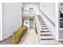 Inviting exterior view with a quaint stairwell, walkway, and nicely manicured landscaping at 1141 W Peppertree Dr # 1141, Sarasota, FL 34242