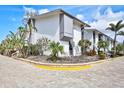 Beautiful exterior corner view featuring tropical landscaping, brick pavers, and ample parking at 1141 W Peppertree Dr # 1141, Sarasota, FL 34242