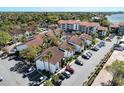 Aerial view of condos near a body of water, featuring a community pool and parking for residents and guests at 1618 Stickney Point Rd # 101, Sarasota, FL 34231