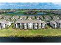 Aerial view showcasing the condo building amidst lush green landscapes, golf courses, and serene water bodies within the community at 18008 Gawthrop Dr # 308, Bradenton, FL 34211