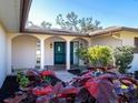 Charming home featuring an inviting front entrance with a brick walkway, colorful landscaping and a double door entry at 1838 Sandalwood Dr, Sarasota, FL 34231
