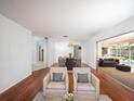 A sun-filled open concept living room offers hardwood floors, and seamless access to outdoor living and dining at 1838 Sandalwood Dr, Sarasota, FL 34231