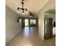 A spacious living room with tile floors, ceiling fan, and a view to the exterior through sliding glass doors at 2105 Pueblo Cir # V2, Sarasota, FL 34231