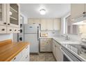 Galley kitchen features white cabinetry, laminate countertops, and appliances at 2326 Canal Dr # G25, Bradenton, FL 34207