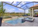 Backyard pool and spa under screened lanai overlooking lake at 4719 Cabreo Ct, Bradenton, FL 34211