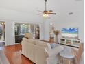 Comfortable living room featuring wood floors, neutral decor, and access to the lanai and bedroom at 5616 Garden Lakes Majestic, Bradenton, FL 34203