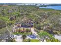 Aerial view of a property surrounded by trees with a view of a waterway and other homes in the distance at 7717 27Th W Ave, Bradenton, FL 34209